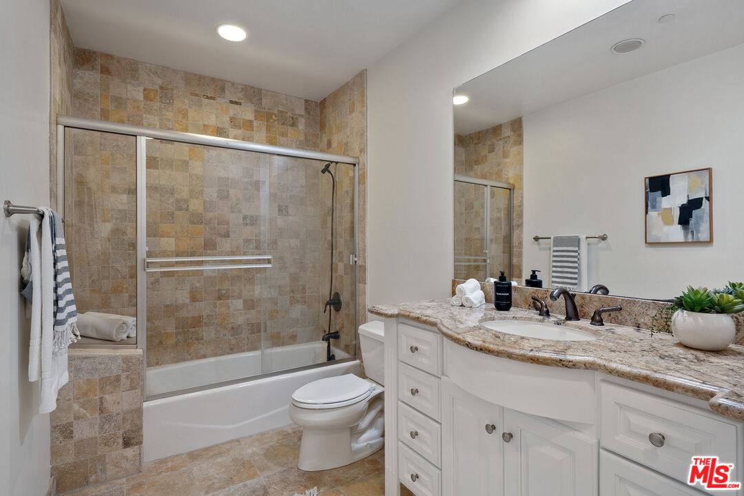 1629 Armacost Avenue, Unit 101 Los Angeles, CA 90025 - Photo 23 of 26 a bathroom with a granite countertop sink toilet and shower