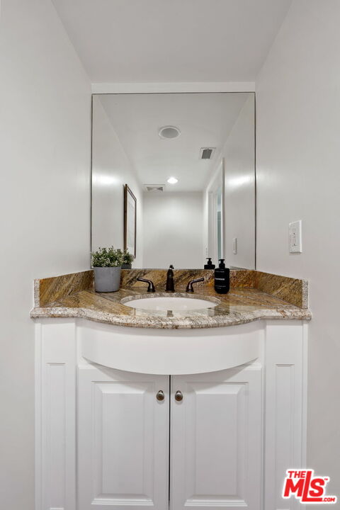 1629 Armacost Avenue, Unit 101 Los Angeles, CA 90025 - Photo 25 of 26 a bathroom with a granite countertop sink and a mirror