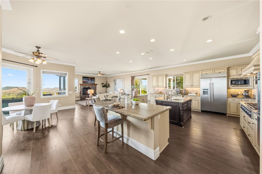 40267 Scanlon Road Temecula, CA 92592 - Photo 21 of 68 a view of a dining room and livingroom with furniture wooden floor a rug a painting and a chandelier