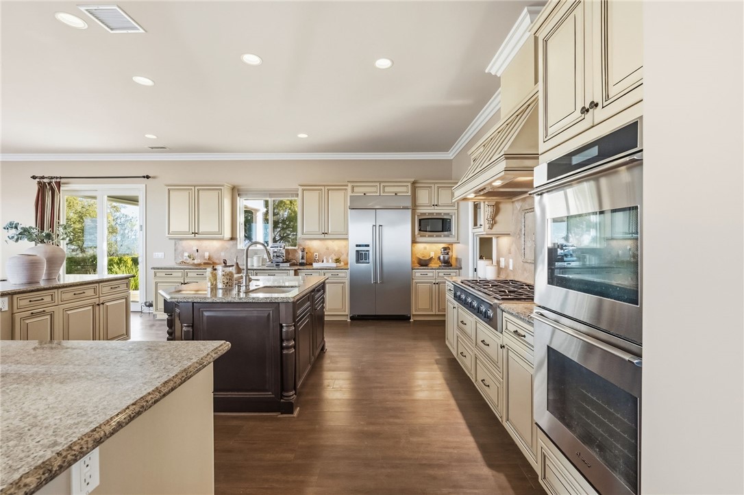 40267 Scanlon Road Temecula, CA 92592 - Photo 32 of 68 a large kitchen with stainless steel appliances granite countertop lots of counter top space and wooden floor