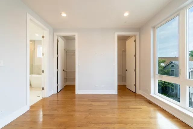 a view of hallway with a large window and wooden floor