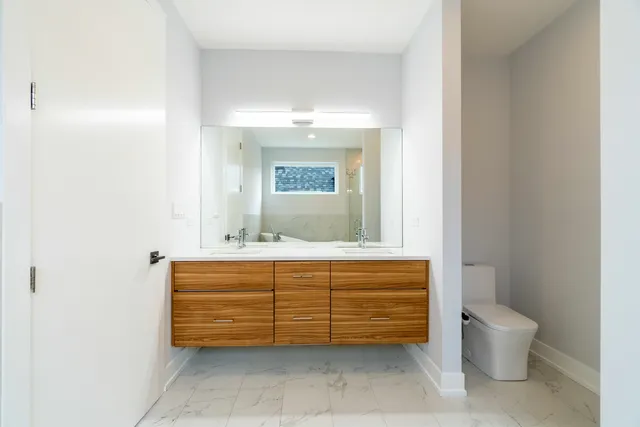 a bathroom with a toilet a sink and mirror
