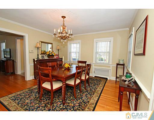 33 Edgewood Road Edison, NJ 08820 - Photo 5 of 25 a dining room with wooden floor a chandelier a wooden table and chairs
