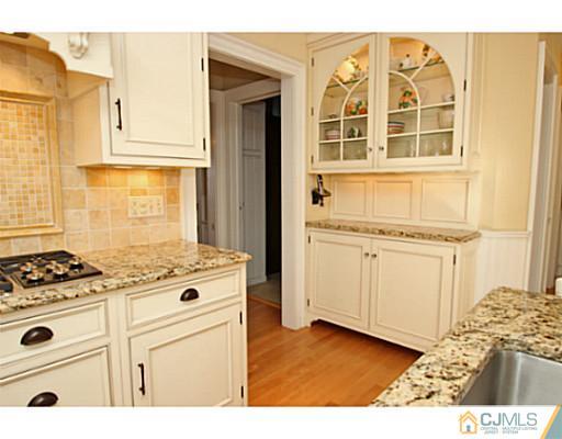 33 Edgewood Road Edison, NJ 08820 - Photo 9 of 25 a kitchen with granite countertop white cabinets and white appliances