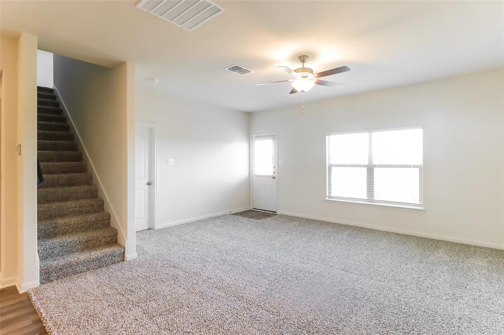 209 Switchback Hill Road Newark, TX 76071 - Photo 15 of 17 an empty room with windows and chandelier fan