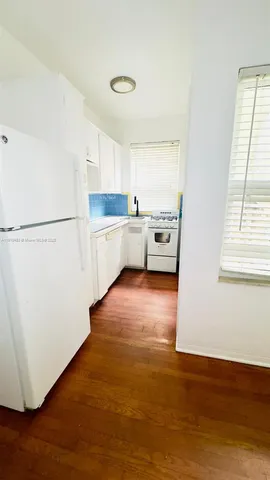 a kitchen with stainless steel appliances a refrigerator sink and white cabinets