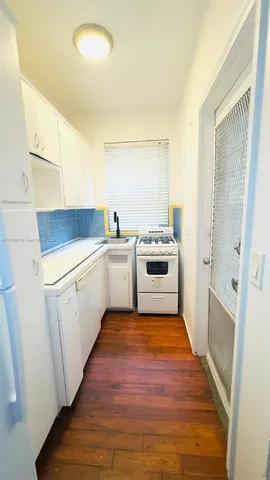 a view of a kitchen with a sink a microwave and cabinets