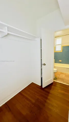a view of a room with wooden floor and white walls