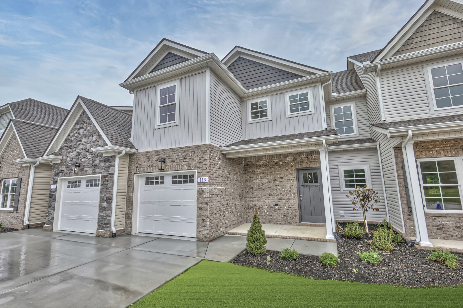 a front view of a house with a garden and plants
