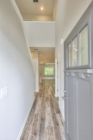 a view of a hallway with wooden floor and staircase