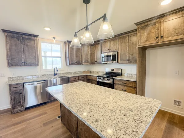 a kitchen with stainless steel appliances granite countertop a sink refrigerator and microwave