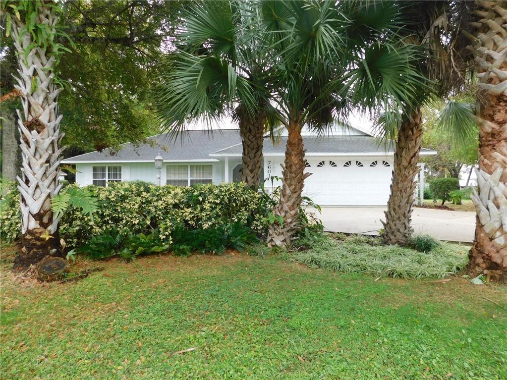 7601 Pensacola Road Fort Pierce, FL 34951 - Photo 1 of 14 a front view of a house with a garden