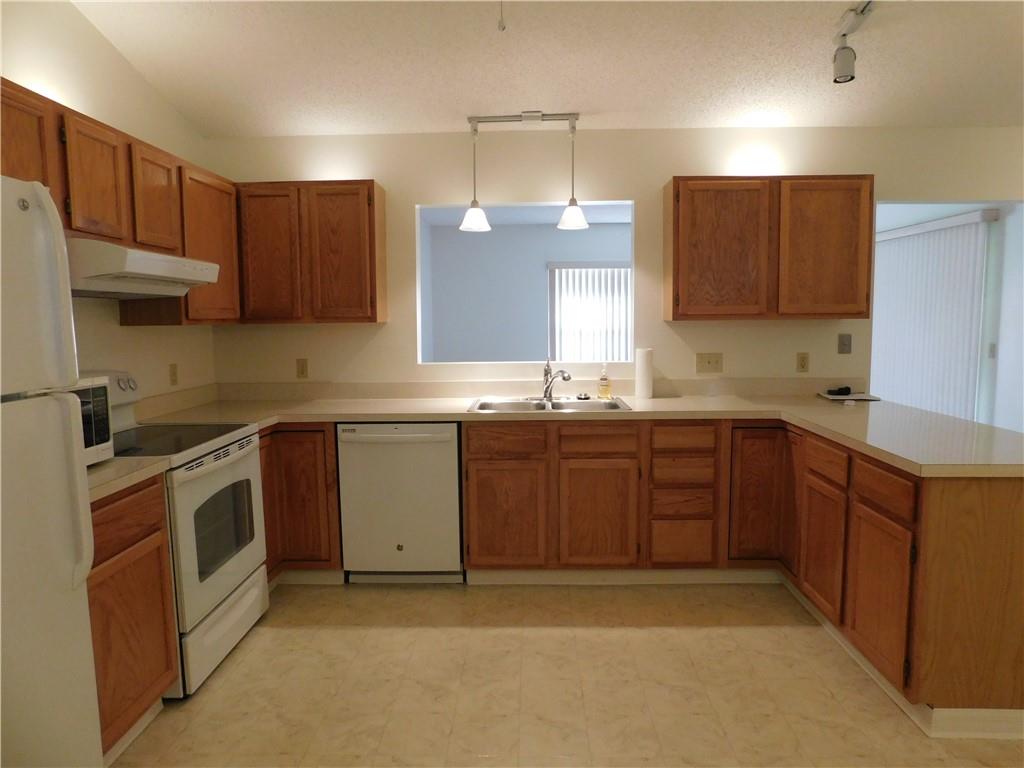 7601 Pensacola Road Fort Pierce, FL 34951 - Photo 5 of 14 a kitchen with a sink a stove and cabinets