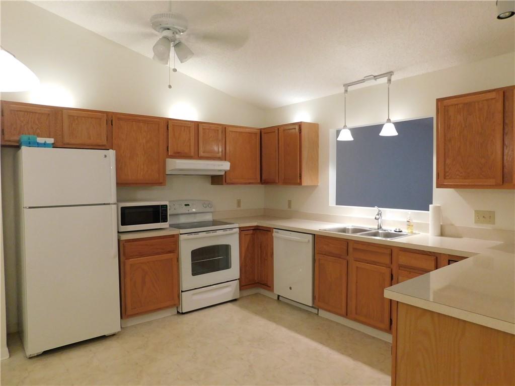 7601 Pensacola Road Fort Pierce, FL 34951 - Photo 6 of 14 a kitchen with stainless steel appliances granite countertop a sink stove and refrigerator