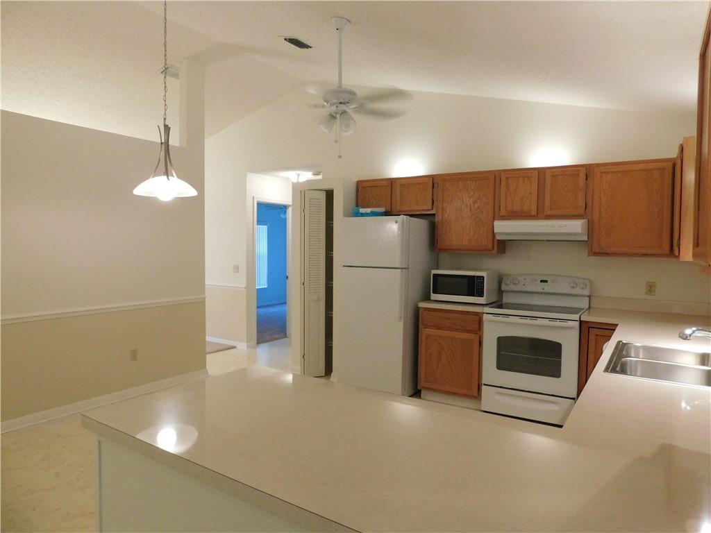 7601 Pensacola Road Fort Pierce, FL 34951 - Photo 7 of 14 a kitchen with refrigerator and cabinets