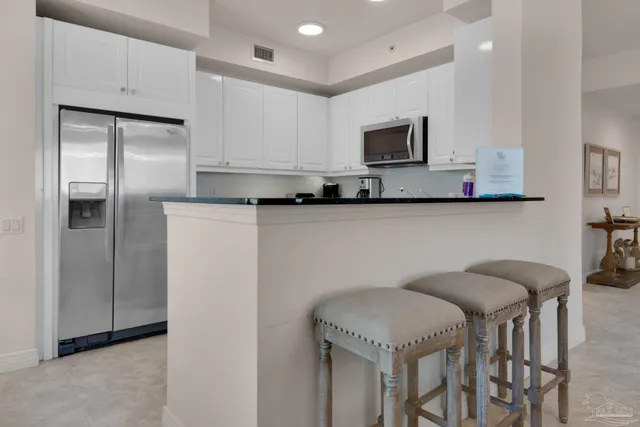 a kitchen with stainless steel appliances granite countertop a refrigerator a stove top oven a sink and dishwasher