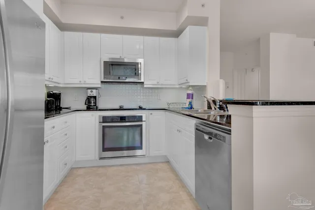 a kitchen with granite countertop a sink stove and refrigerator