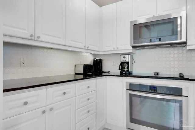 a kitchen with white cabinets and white appliances