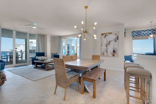 a living room with furniture a chandelier and a dining table