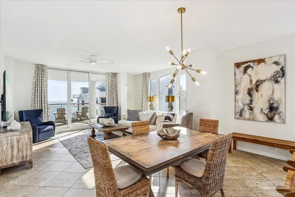 a view of a dining room and livingroom with furniture wooden floor a rug and a chandelier