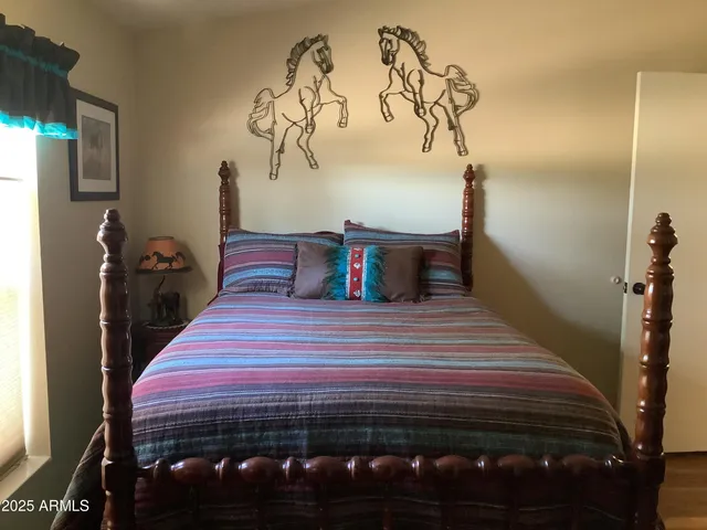 a bedroom with a bed and a painting on the wall
