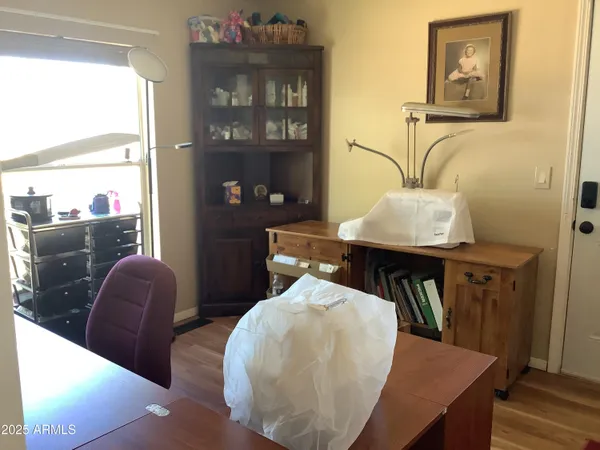 a bedroom with a bed and dresser with wooden floor