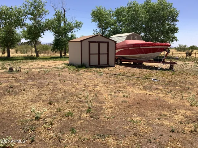 a backyard of a house with wooden fence and a tree