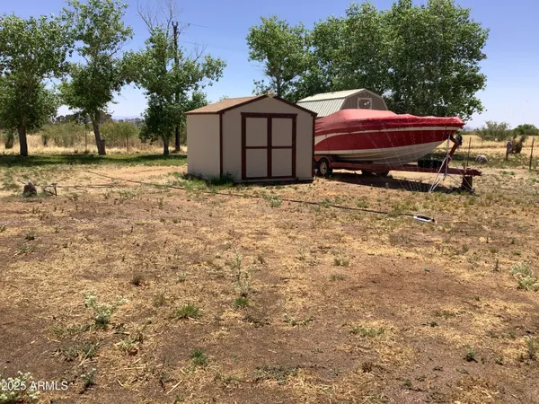 a backyard of a house with wooden fence and a tree