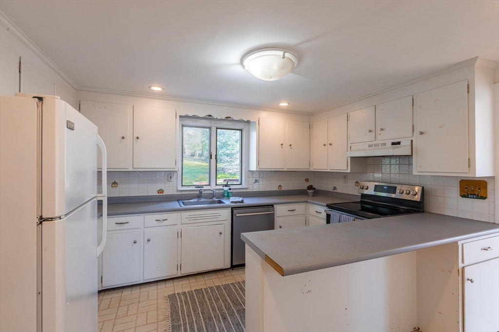 41 Labor In Vain Road Ipswich, MA 01938 - Photo 16 of 33 a kitchen with a sink a stove a refrigerator a center island and a window