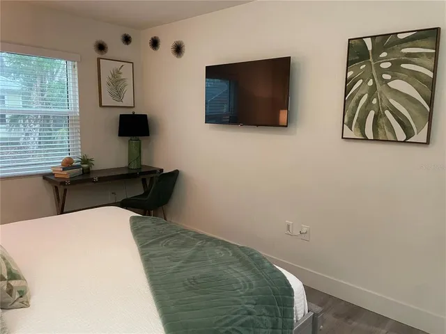 a bedroom with a bed and a flat screen tv