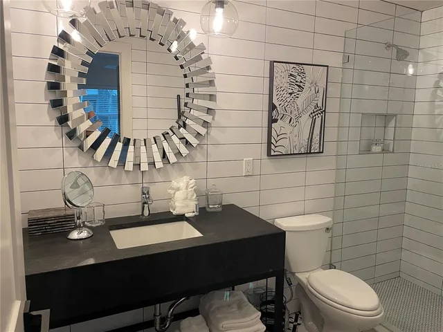 a bathroom with a sink a toilet and shower curtain