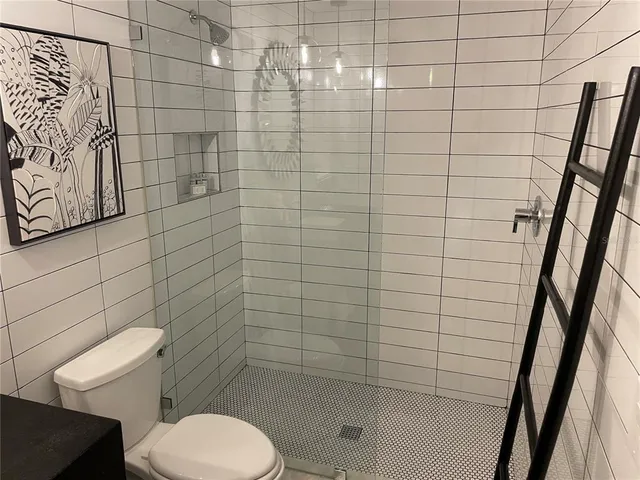 a bathroom with a toilet and a shower