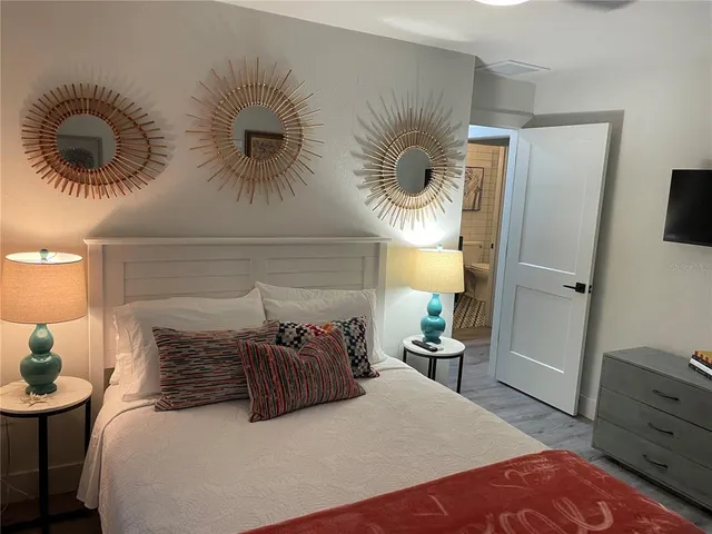 a bedroom with a bed and a lamp on dresser