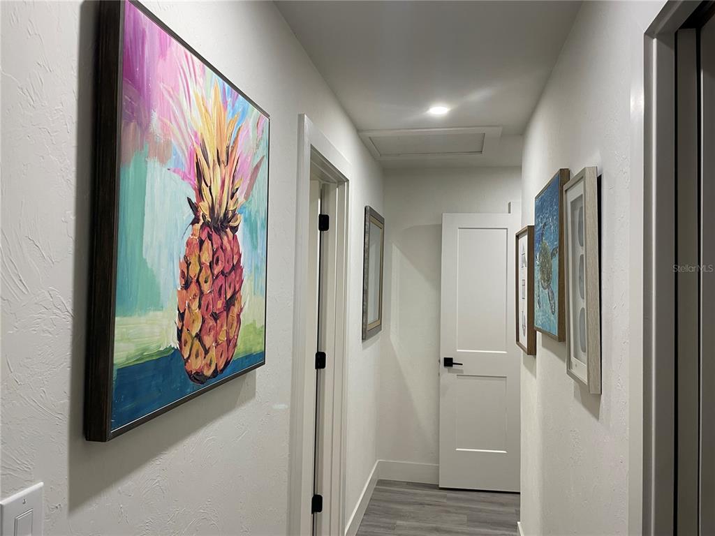 1920 Morrill Street, Unit PINEAPPLE Sarasota, FL 34236 - Photo 28 of 37 a view of a hallway with wooden floor and paintings on the wall