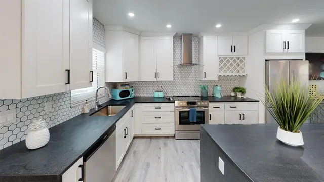 a kitchen with white cabinets and appliances