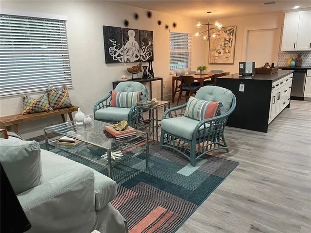 a living room with furniture a rug and a dining table