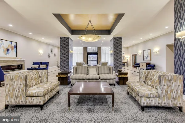 a living room with furniture and a chandelier