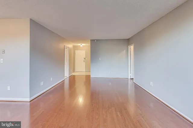 a view of an empty room with wooden floor