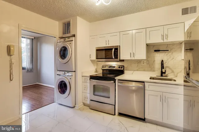 a kitchen with white cabinets and stainless steel appliances