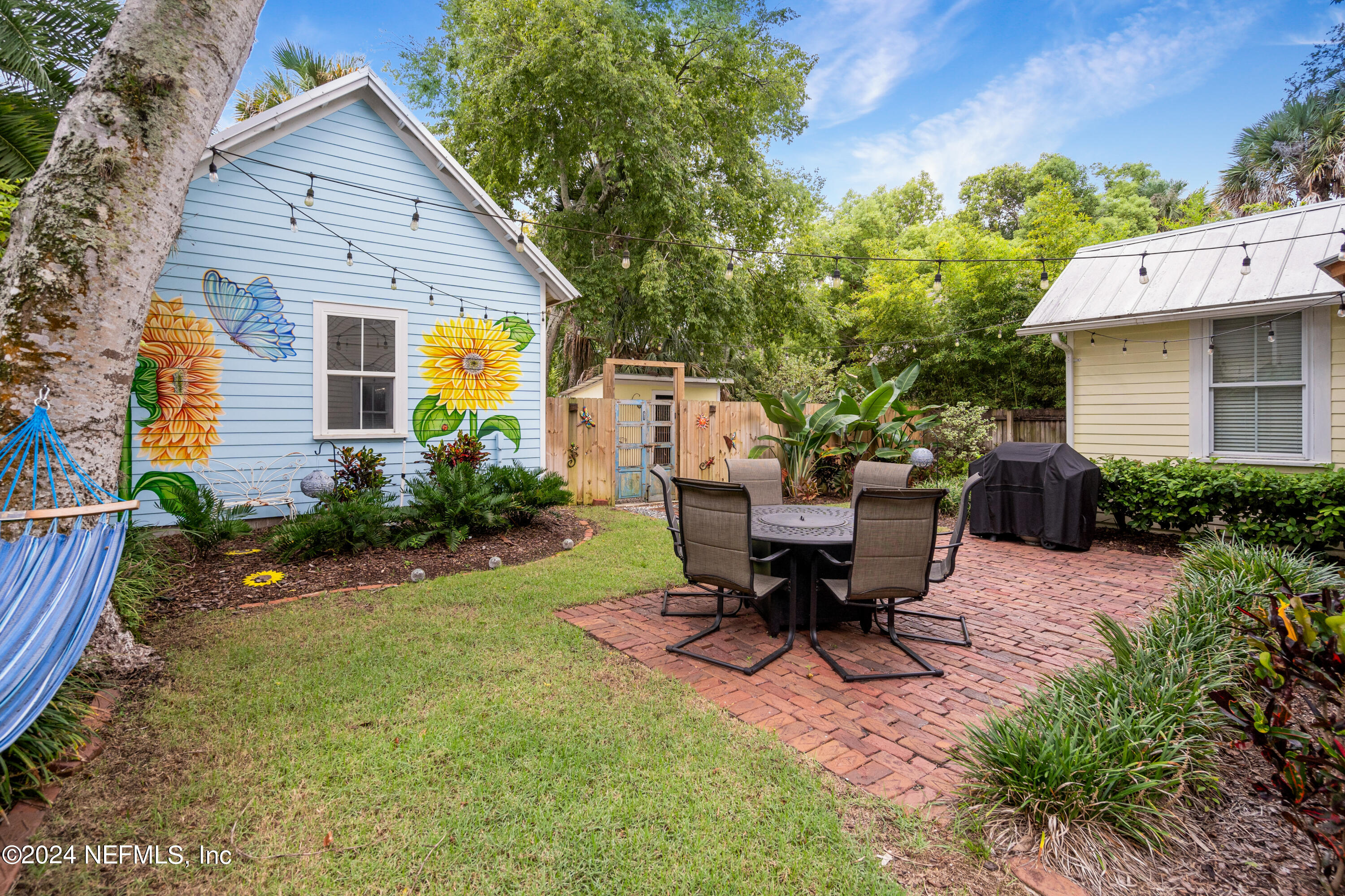 15 Rohde Avenue St. Augustine, FL 32084 - Photo 1 of 36 a view of a patio with table and chairs and potted plants with wooden fence