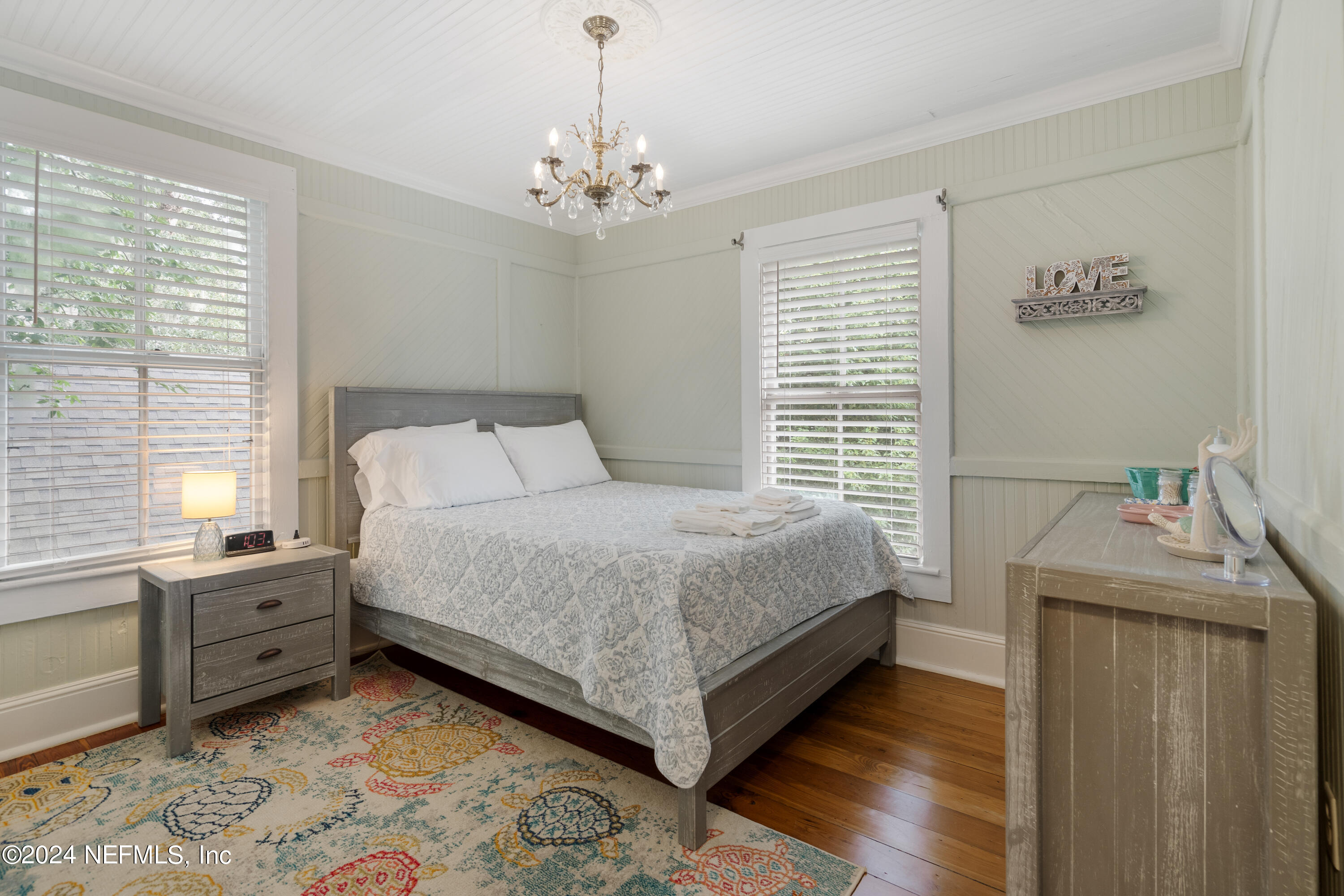 15 Rohde Avenue St. Augustine, FL 32084 - Photo 34 of 36 a bedroom with a bed and a chandelier