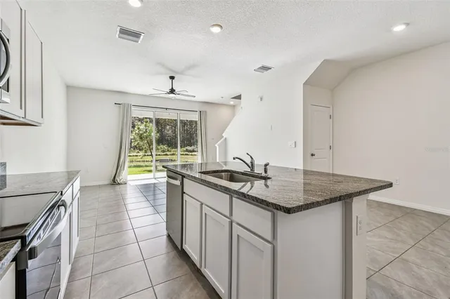 a kitchen with stainless steel appliances granite countertop a sink stove and cabinets