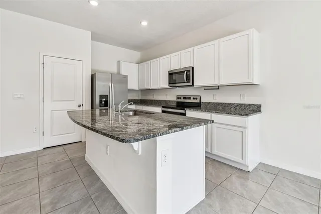 a kitchen with stainless steel appliances granite countertop a sink stove and cabinets