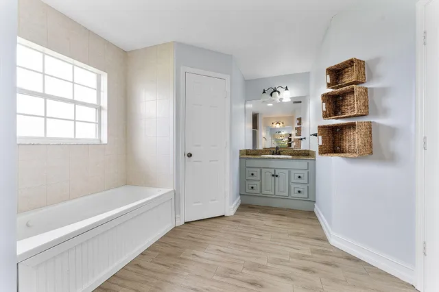 a bathroom with a tub sink and a window