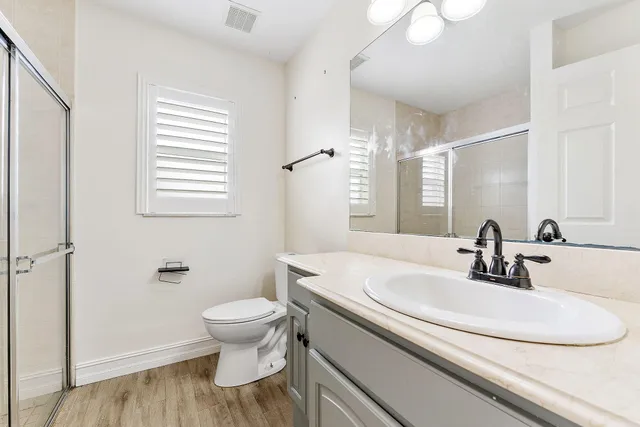 a bathroom with a sink a toilet and a mirror