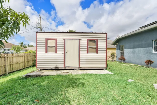 a view of a house with a small yard and wooden fence