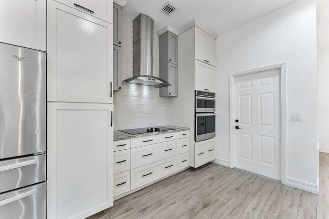 a kitchen with white cabinets and refrigerator
