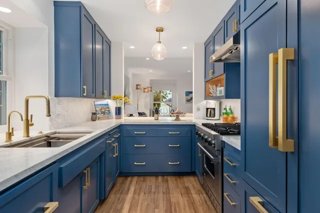 a kitchen with stainless steel appliances granite countertop a stove a sink and a refrigerator