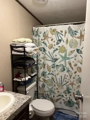 a bathroom with a granite countertop toilet sink and mirror