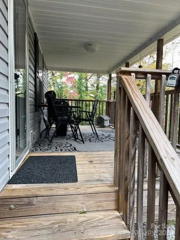 a view of a patio with table and chairs with wooden floor and fence